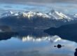 Snow-capped peaks of Southeast Alaska reflected in the still waters of spring — the Inside Passage at its most breathtaking.