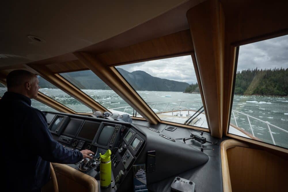 Captain Jim at the helm of M/Y Dauntless, steering through floating ice in LeConte Bay, Southeast Alaska.