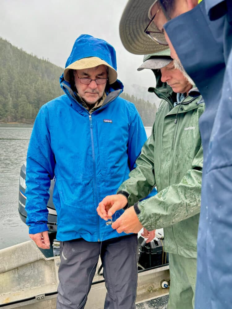 Captain Jim shows guests how to rig fishing gear on a rainy day in Southeast Alaska. 